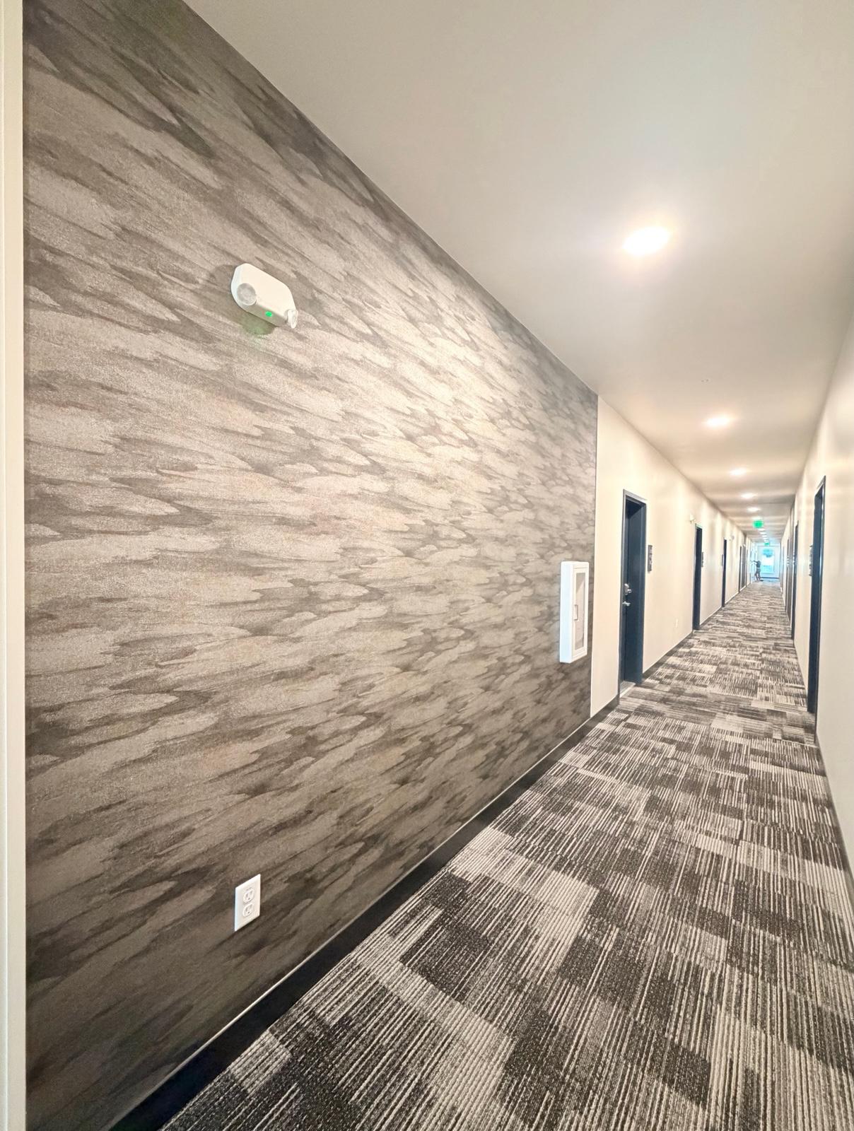 Textured commercial-style wallpaper accent wall installation